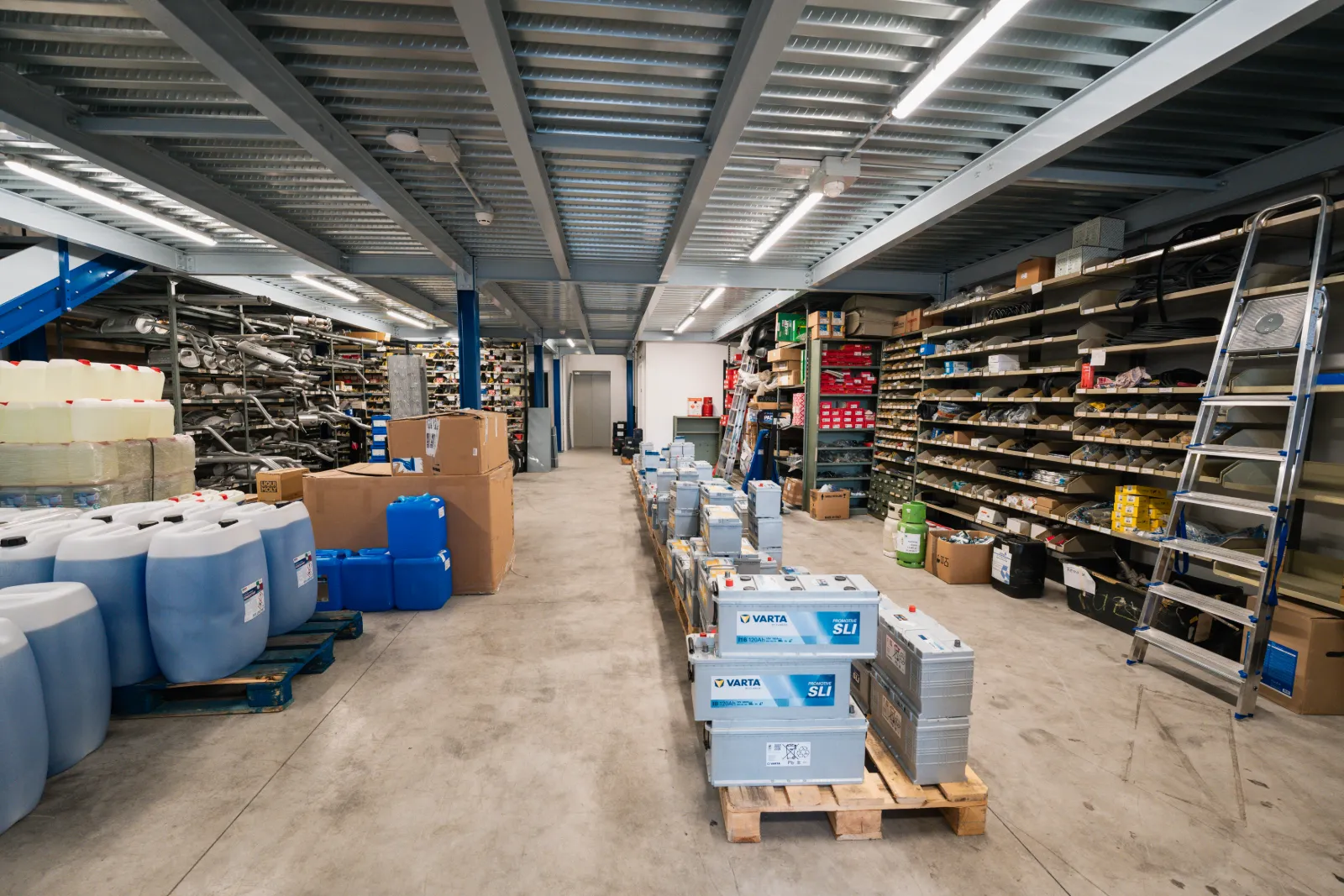 Blick in die Lagerhalle mit Regalen und Batterien auf Paletten